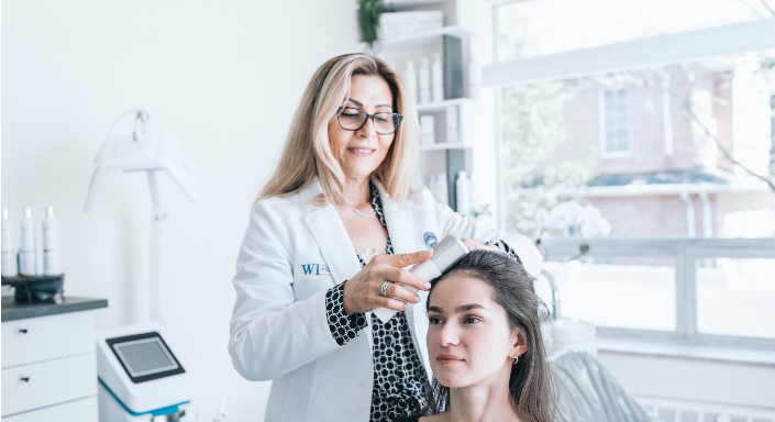 A trichologist at Simone Trichology performing a dandruff treatment to address dry scalp and improve overall scalp health